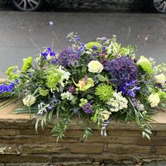 Purples and greens casket spray 
